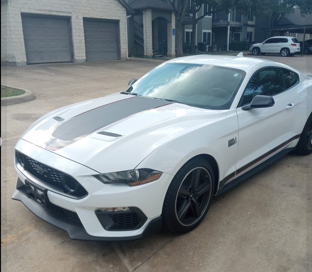 White Ford Mustang Mach 1 parked in a driveway, photographed three-quarters from the front
