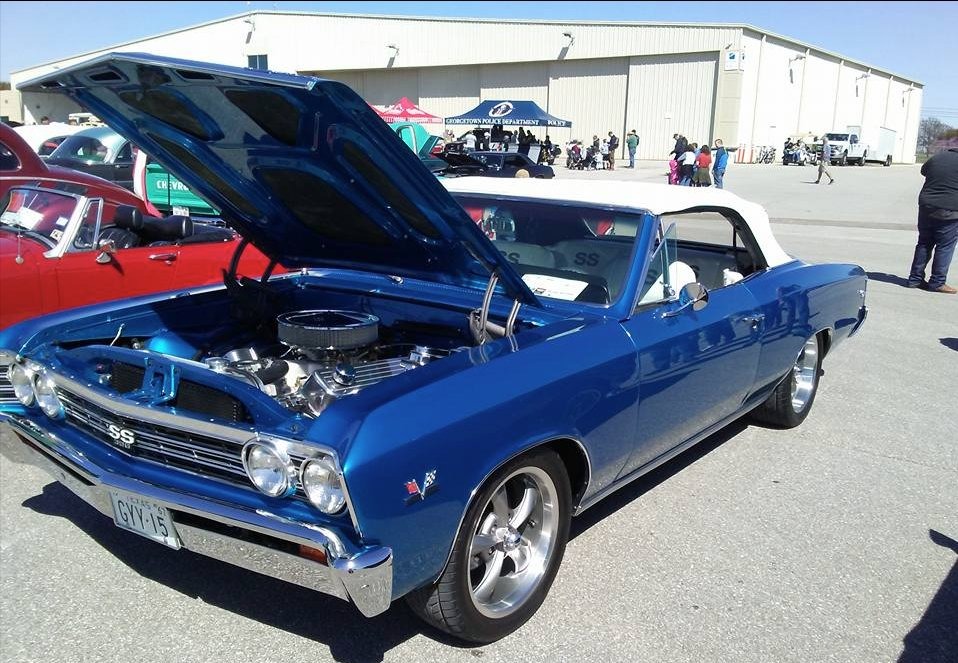 Blue 1967 Chevy Chevelle SS convertible with hood open at a car show