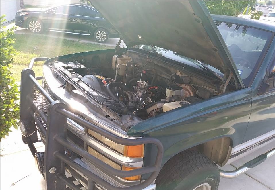 Green OBS-era Chevy truck with hood open showing engine work